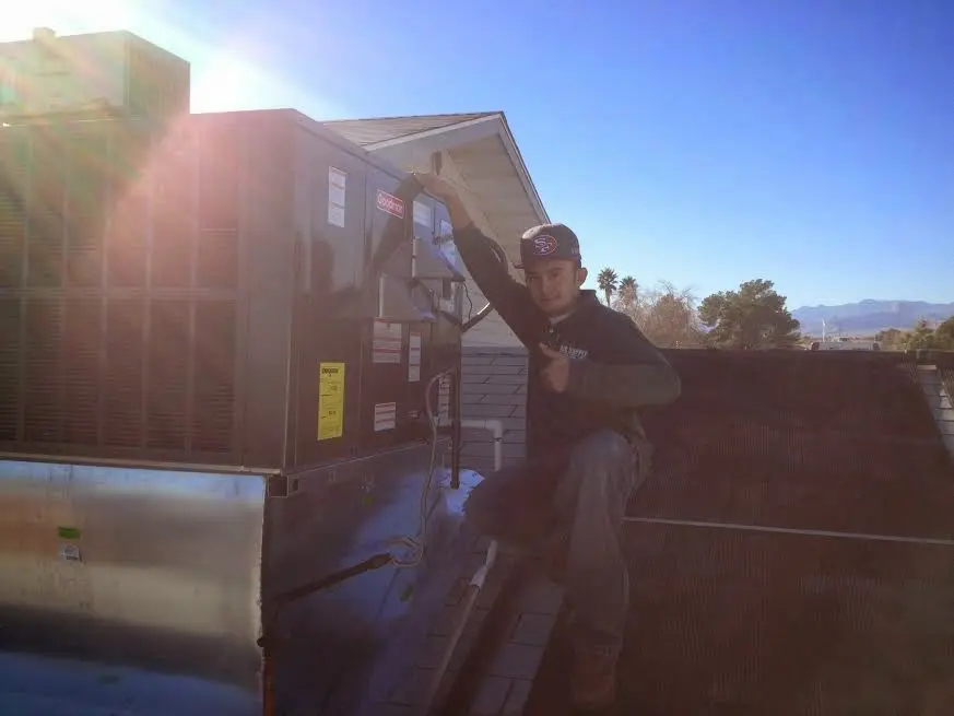 HVAC technician performing AC Tune-Up on a rooftop unit in Conway